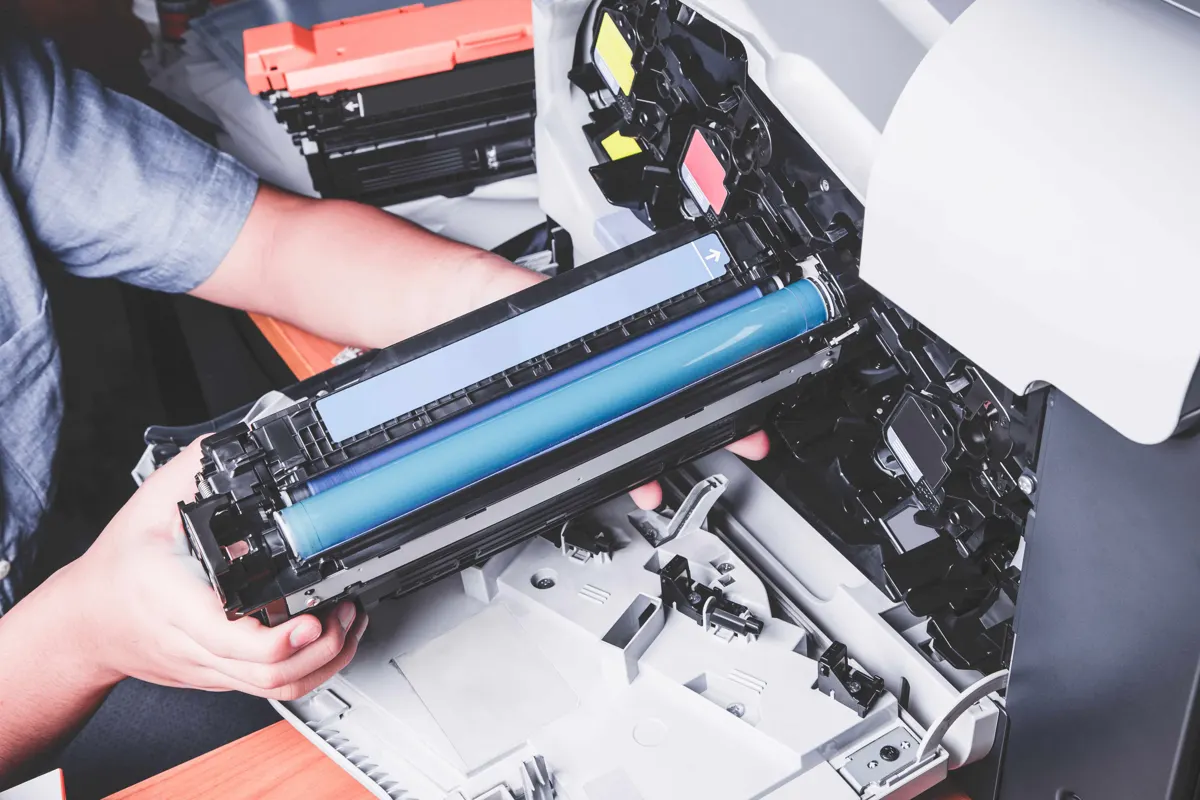 Technician replacing a toner cartridge in an office copier